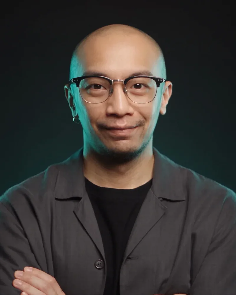 Nelson How in a black studio with teal rim light